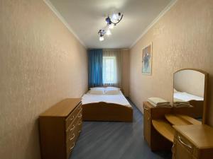 ein kleines Zimmer mit einem Bett und einem Spiegel in der Unterkunft Comfy Apartment Most City Area in Dnipro