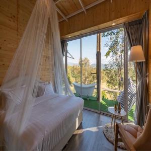 una camera da letto con un letto, un'amaca e una finestra di แคมป์ต๊ะต่อนยอน แม่กำปอง เชียงใหม่ CAMP Ta-Torn-Yorn Maekampong Chiang Mai a Mae On Altre 185 foto