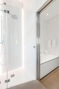 a white bathroom with a shower and a sink at Hotel C2 in Marseille