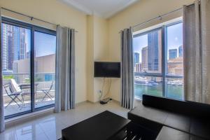 ein Wohnzimmer mit einem Sofa und großen Fenstern in der Unterkunft Bay Central apartment with awesome Marina view in Dubai