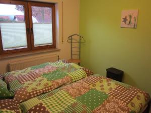 a bedroom with a bed with a quilt on it at Ferienwohnung Sonja Sinsheim in Sinsheim