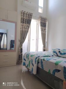 a bedroom with a bed and a large window at Alysahouse - 2 Bedrooms, Dekat JTP3 in Batu