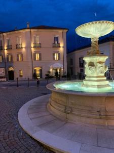 una fuente en una plaza frente a un edificio en Palazzo del Senatore en Atina