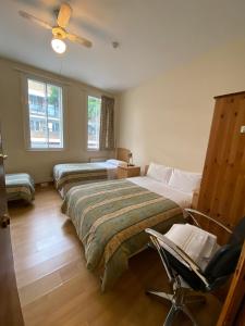 um quarto com duas camas e uma cadeira. em Seven Dials Hotel Annexe em Londres