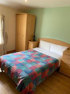 a bedroom with a bed with a colorful quilt on it at Seven Dials Hotel Annexe in London