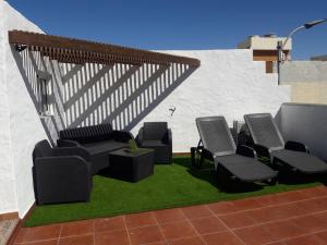 een groep stoelen en tafels op een patio bij Casa los abuelos 1 in La Goleta