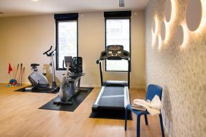 a gym with treadmill and exercise equipment in a room at Domitys - Galilée in Cergy