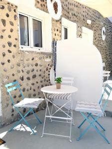 two chairs and a table and a table and chairs at Kampanelia Village Suites in Fira