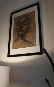a painting of a woman is hanging on a wall at SAN GIACOMO LOFT in Caltagirone