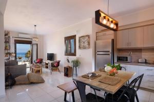 a kitchen and living room with a table and chairs at "Oak Wood" - Sea View Holidays Home by Sky Hill Resorts in Sfakaki