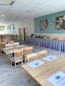 una sala da pranzo con tavoli e sedie in legno di Ośrodek Wypoczynkowo-Rehabilitacyjny Perła Borów a Tleń