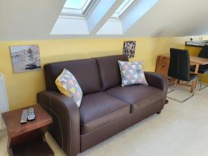 sala de estar con sofá marrón y mesa en Lochview en Swannay