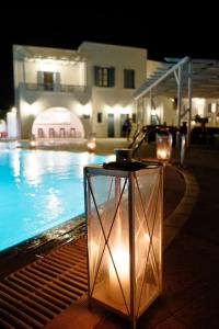 una mesa frente a una piscina por la noche en Castellano Village en Analipsi