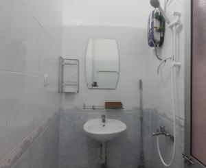 ein weißes Badezimmer mit einem Waschbecken und einem Spiegel in der Unterkunft Lisa Homestay in Hoi An