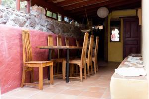 una mesa y sillas en una habitación con una pared rosa en El Drago Rural House en Alajeró