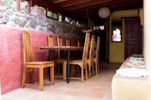 a table and chairs in a room with a pink wall at El Drago Rural House in Alajeró