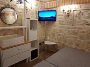 łazienka z telewizorem na kamiennej ścianie w obiekcie Travel Solution - SeaView & Roman Apartments CIR 13014 w Anzio