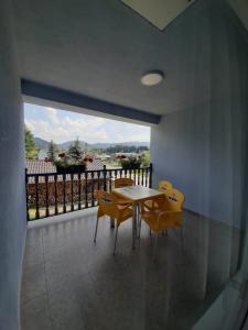 a dining room with a table and chairs on a balcony at Casa Roua Muntilor in Vatra Dornei
