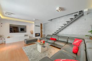 Una sala de estar con un sofá y una escalera. en Apartment Rex Exclusive, en Split
