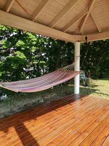a hammock hanging from a pergola on a deck at Golcza Vita in Choszczno