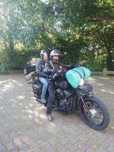Dos personas están sentadas en una motocicleta. en Villa Bretonne, en Langueux