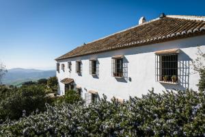 uma casa branca com janelas numa colina em La Fuente del Sol Hotel & Spa em Antequera