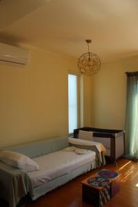 a bedroom with two beds and a chandelier at Zenmar in Zakynthos Town