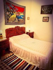 ein Schlafzimmer mit einem Bett und einem Wandgemälde in der Unterkunft Dar EL Hamra Maison Typique in Mahdia