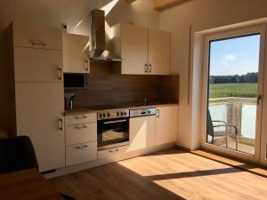 a kitchen with a stove and a large window at Ferienwohnungen Familie Mapenzi in Waischenfeld