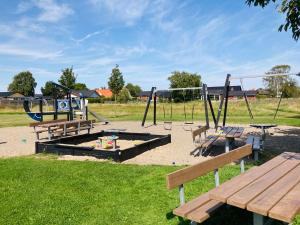a park with two benches and a playground at Det blågrønne Hus in Hals