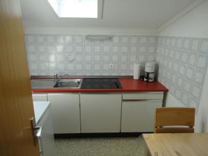 a kitchen with a sink and a red counter top at Haus Vogel-Nest in Reit im Winkl