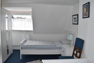 a small bedroom with a bed and a chair at Haus Pries in Kiel