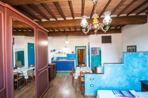 una cucina e una sala da pranzo con pareti blu e soffitti in legno di CASA PASQUA - Monolocale Città della Pieve a Città della Pieve