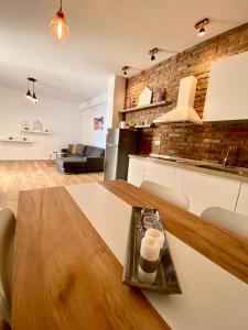 cocina y sala de estar con mesa de madera en Rock Apartments, en Sarandë