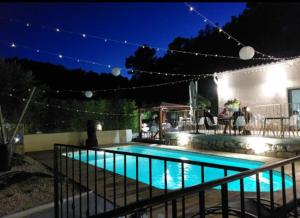 a swimming pool in a yard at night at Auberge les Galets in Peyruis