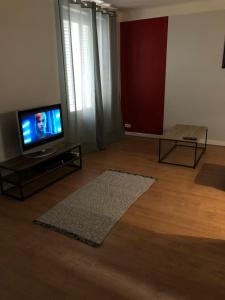 a living room with a flat screen tv and a rug at Monfs Apparts Clermont-Ferrand, pres de toute commodites in Clermont-Ferrand