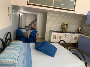 una camera con letto e tavolo con sedie blu di Loft Rapisardi a Catania