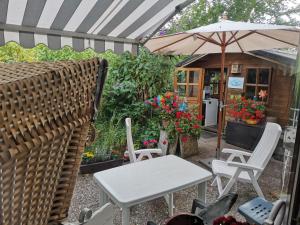 een patio met een tafel en stoelen en een parasol bij Österdeichstrich in Oesterdeichstrich