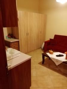 a living room with a red couch and a table at Dolphins DreamHouse in Agios Ioannis Pelio +4 photos