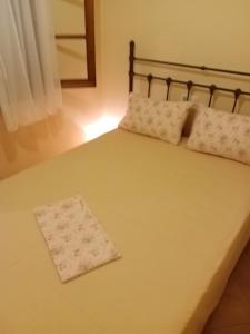 a bed with two pillows on top of it at Dolphins DreamHouse in Agios Ioannis Pelio