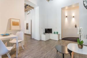 a living room with tables and chairs and a tv at Casa Manara in Trastevere in Rome