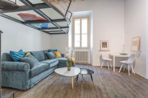 a living room with a blue couch and a table at Casa Manara in Trastevere in Rome