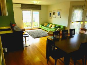 a living room with a green couch and a table at Trogir family space 90m2 in Trogir