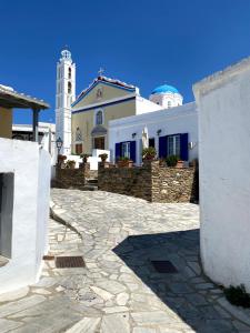 a white building with a clock tower in the background at Traditional holiday home in Kékhros