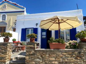 a blue and white house with an umbrella at Traditional holiday home in Kékhros