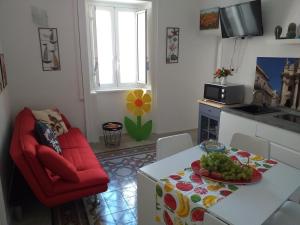a kitchen with a red chair and a table with a plate of fruit at Casa Dreaming Ortigia in Siracusa