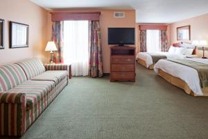 a hotel room with two beds and a couch at GrandStay Hotel & Suites Downtown Sheboygan in Sheboygan