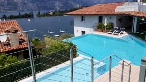 a house with a swimming pool and a view of the water at Hotel Garden in Malcesine