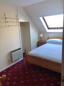 a bedroom with a bed and a skylight at Cosy holiday home, Scalloway, Shetland. in Scalloway
