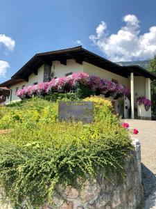 ein Gebäude mit Blumen davor in der Unterkunft Appartements Rosengarten in Söll